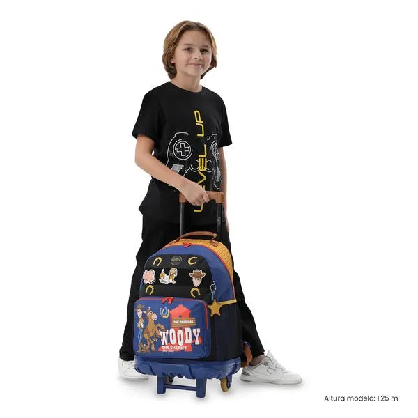 Child holding a colorful suitcase with character designs on a white background