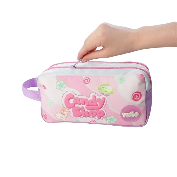 A pink and white zippered pencil case with a purple handle, decorated with 'Candy Shop' and 'relie' graphics, held by two hands against a white background.