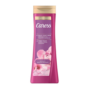 A bottle of Caress Peony & Almond Blossom body wash, featuring a vibrant magenta pink bottle with a gold cap and floral graphics, set against a plain white background.