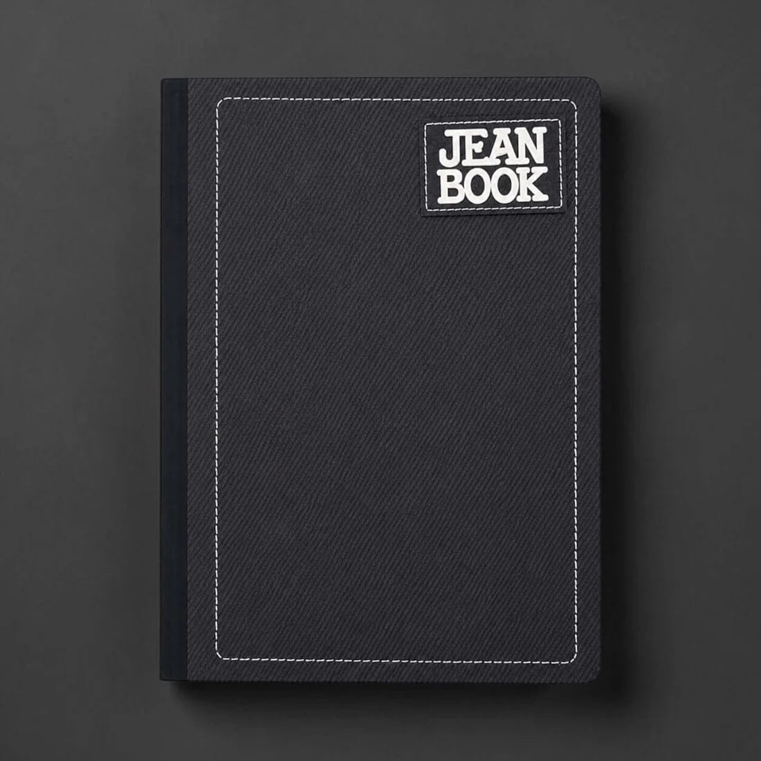 Black notebook with 'JEAN BOOK' label on a dark gray background